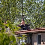 Two men fix the roof of an old house - Ukraine, Odessa, 11,06,2020