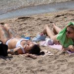 Two girls sunbathe on the beach at the beginning of summer - Ukraine, Odessa, 11,06,2020