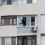 young woman washing windows - Ukraine, Odessa, 11,06,2020