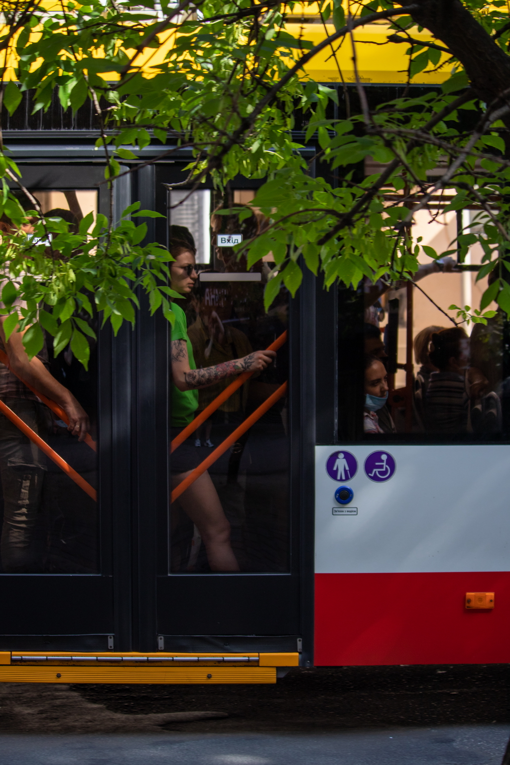 People ride in a trolley bus leaning against the door - Ukraine, Odessa, 11,06,2020