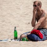 Untidy man with beer smokes on the beach - Ukraine, Odessa, 11,06,2020