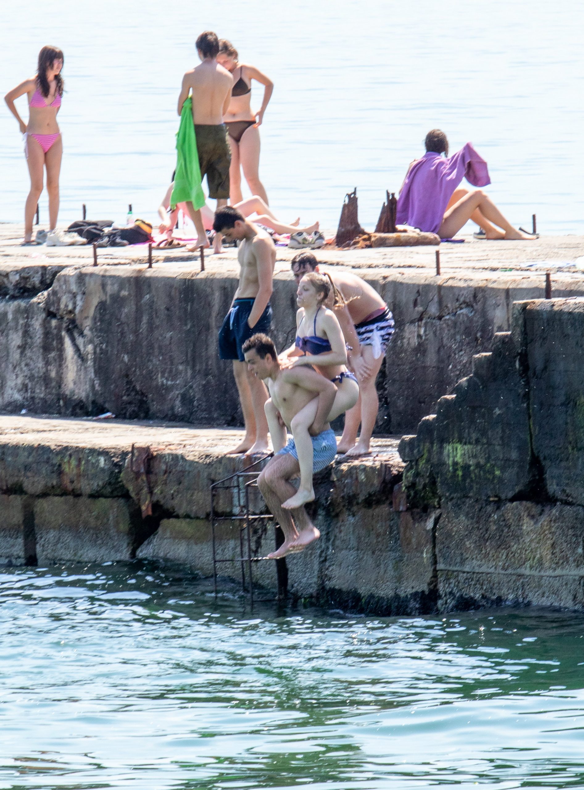 Подростки прыгают в воду на море