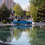 Синий ретро автомобиль у фонтана