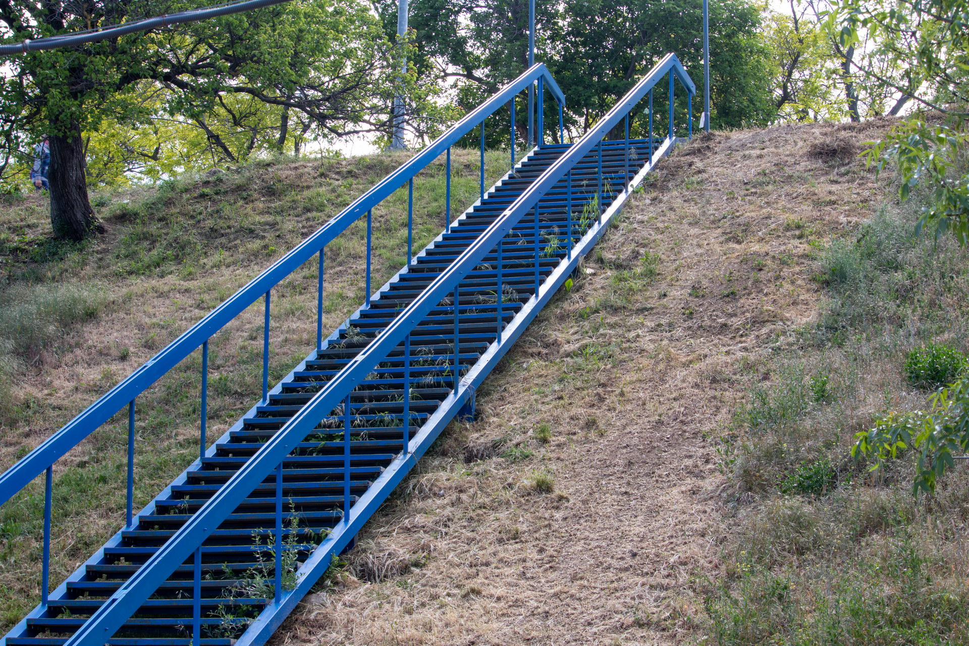 Синяя лестница из металла на обрыве